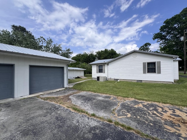 31 Marler St, Tracy City, TN 37387 - view of side of home featuring a garage, metal roof, cooling unit, an outbuilding, and a lawn