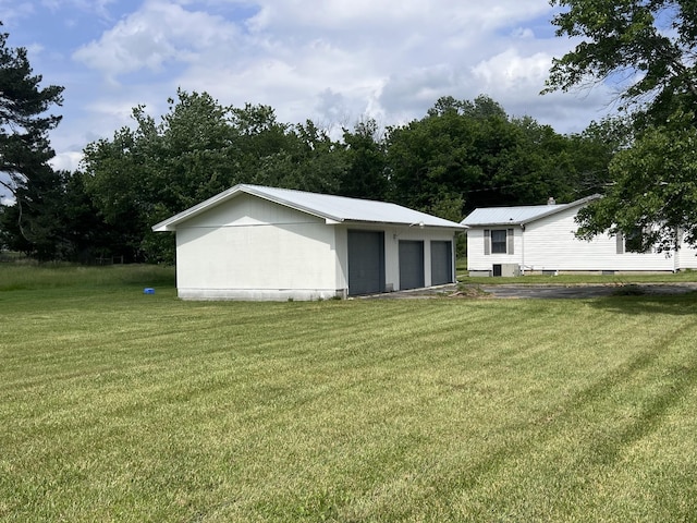 31 Marler St, Tracy City, TN 37387 - rear view of property with an outdoor structure, a detached garage, a lawn, and metal roof