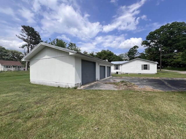 31 Marler St, Tracy City, TN 37387 - view of property exterior featuring an attached garage, driveway, an outbuilding, and a lawn