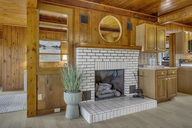 living room featuring visible vents, wooden walls, light wood-style flooring, and wood ceiling