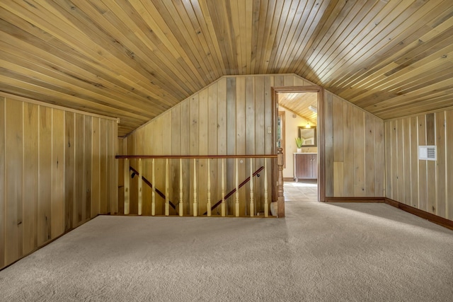 bonus room with lofted ceiling, wood walls, and carpet