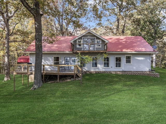 back of house featuring a lawn, a deck, and metal roof