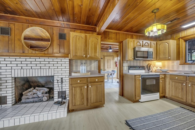 kitchen with white electric stove, light countertops, decorative backsplash, and stainless steel microwave