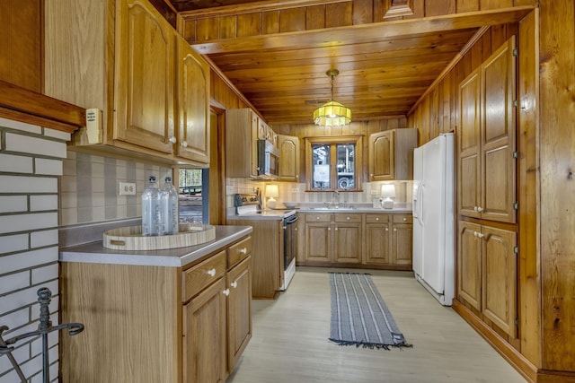 kitchen featuring stainless steel microwave, a sink, white refrigerator with ice dispenser, range with electric stovetop, and backsplash