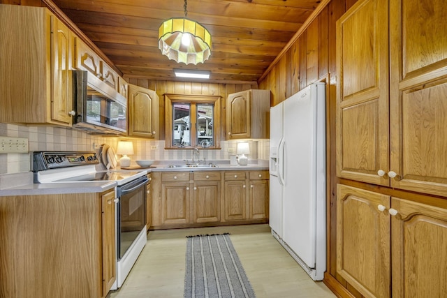 kitchen featuring decorative backsplash, light countertops, a sink, and white appliances