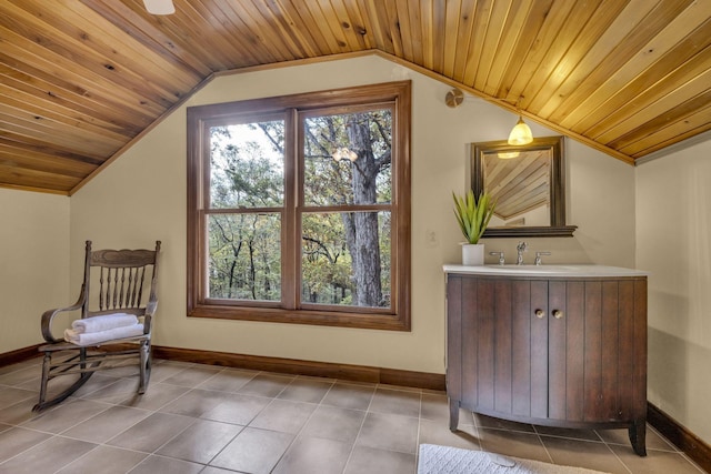 interior space with baseboards, lofted ceiling, wood ceiling, and vanity