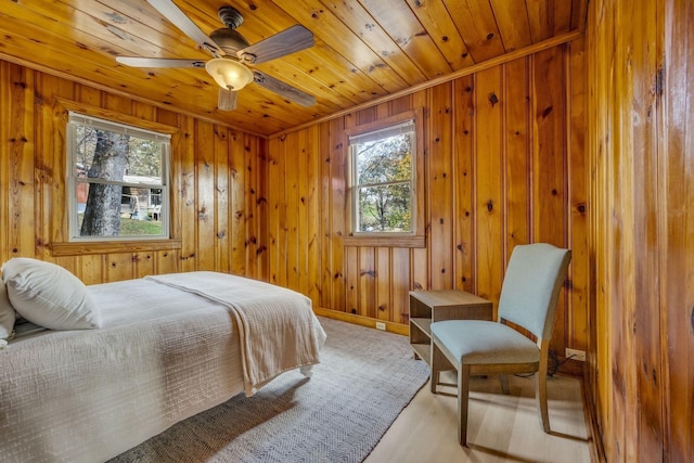 bedroom featuring wood ceiling, baseboards, and wooden walls
