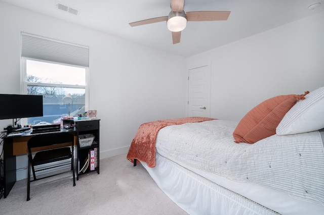 bedroom featuring a ceiling fan, light carpet, baseboards, and visible vents