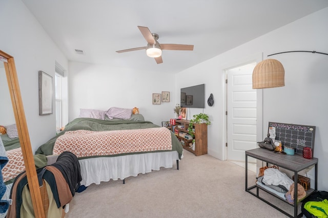 bedroom featuring visible vents, a ceiling fan, and light colored carpet