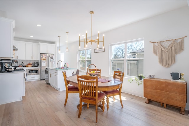 dining space featuring a chandelier, recessed lighting, and light wood finished floors