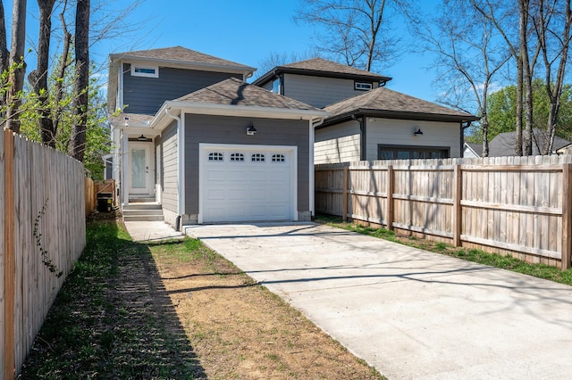 garage featuring fence and concrete driveway