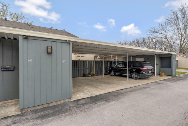 covered parking lot featuring fence