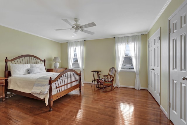 bedroom with baseboards, crown molding, a ceiling fan, and hardwood / wood-style floors