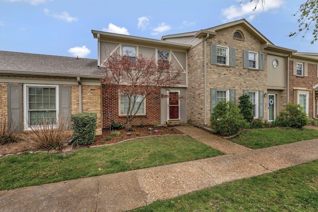 view of front of house with a front yard and brick siding