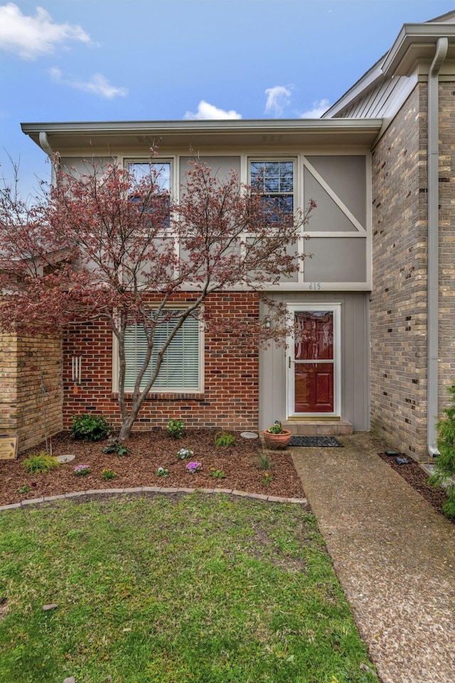 view of front of property featuring brick siding and a front lawn
