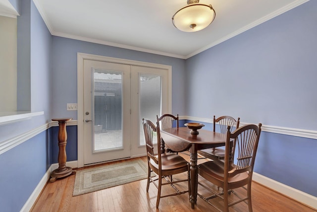 dining room with baseboards, ornamental molding, wood finished floors, and french doors