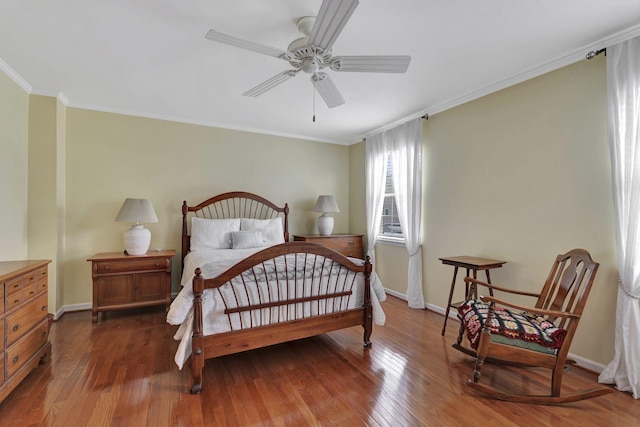 bedroom featuring hardwood / wood-style floors, baseboards, and crown molding