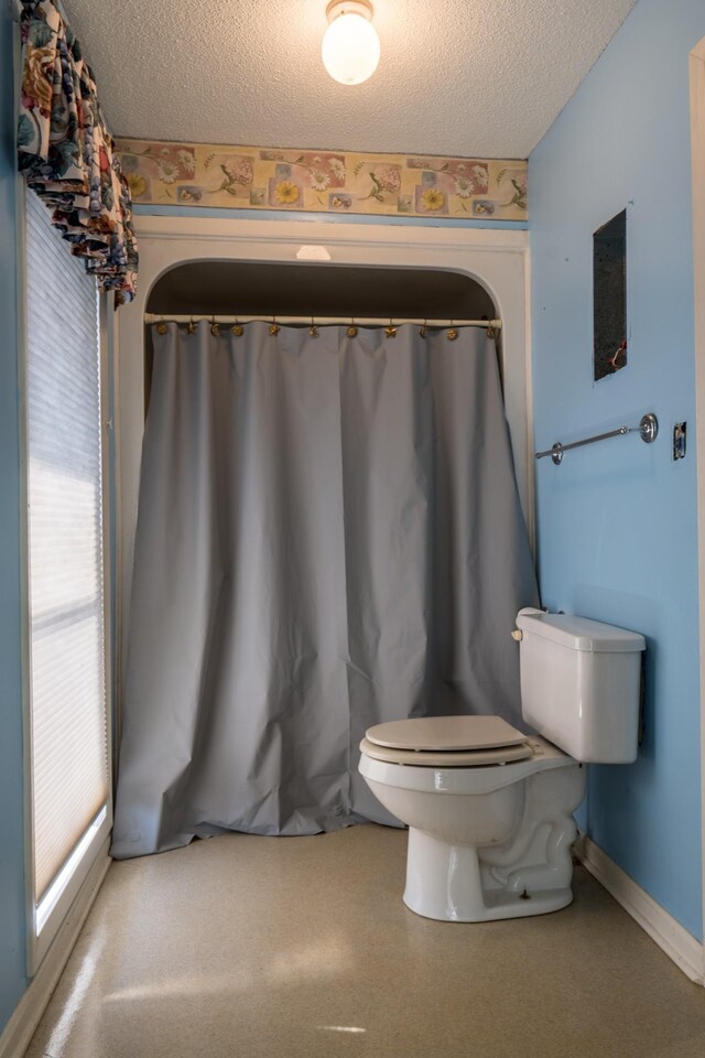 2589 Presley Ridge Rd, Sardis, TN 38371 - bathroom featuring toilet, baseboards, and a textured ceiling
