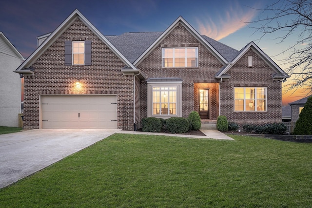 traditional-style house featuring brick siding, concrete driveway, and a yard