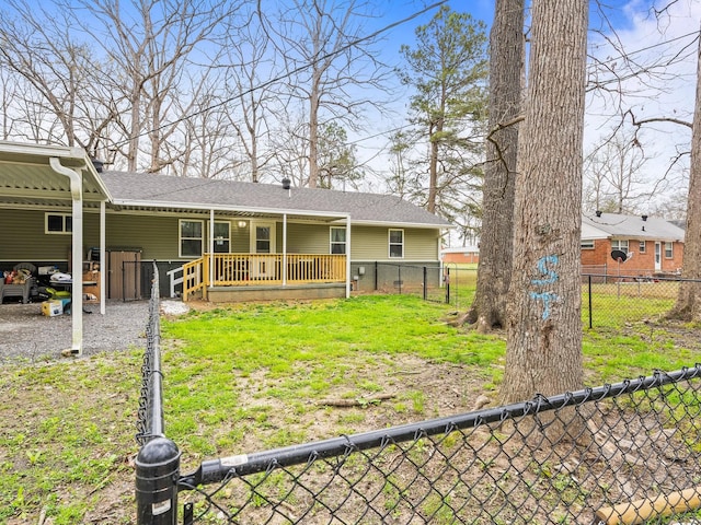 rear view of house featuring a shingled roof, a lawn, a carport, and fence private yard