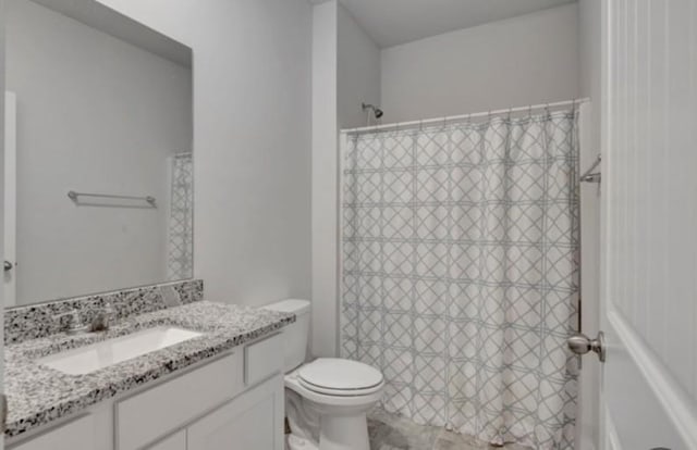 full bathroom with curtained shower, toilet, and vanity