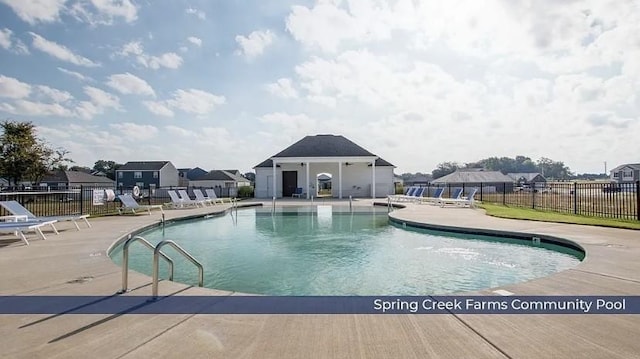 pool with a patio and fence