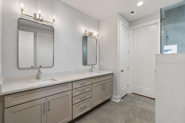 full bathroom featuring double vanity, a sink, tile patterned floors, and walk in shower