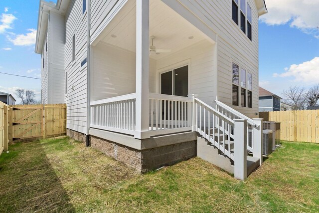 exterior space with a lawn, ceiling fan, a gate, and fence