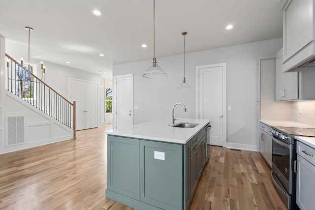 kitchen featuring visible vents, light wood-style flooring, a sink, and stainless steel appliances