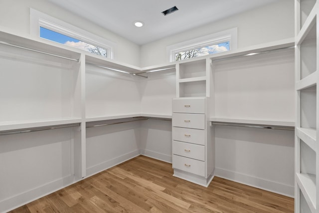 walk in closet with light wood finished floors