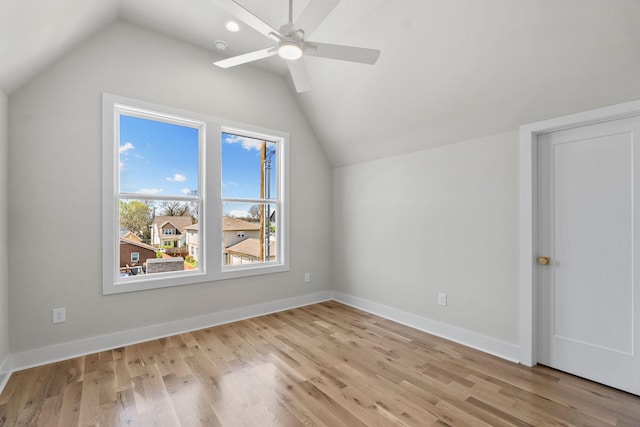 additional living space with baseboards, light wood-type flooring, lofted ceiling, and a ceiling fan