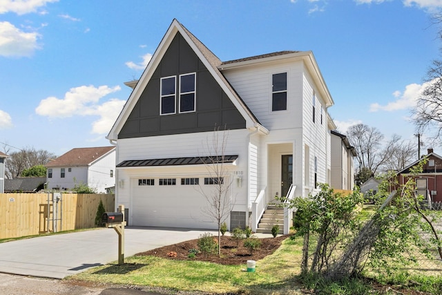 view of front of home featuring driveway, fence, and a garage
