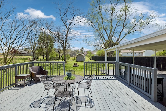 3132 Stafford Dr, Nashville, TN 37214 - deck with an outbuilding, a fenced backyard, a storage unit, outdoor dining space, and a yard