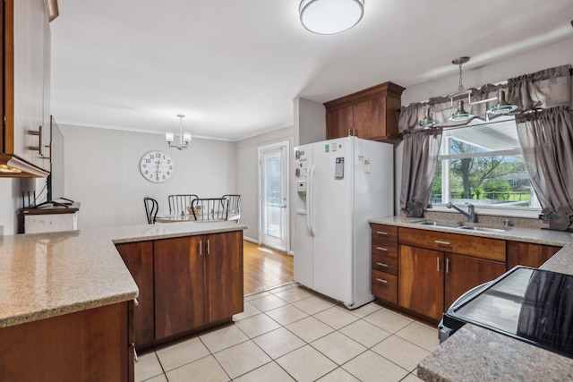 3132 Stafford Dr, Nashville, TN 37214 - kitchen with a chandelier, a peninsula, black range with electric cooktop, a sink, and white refrigerator with ice dispenser