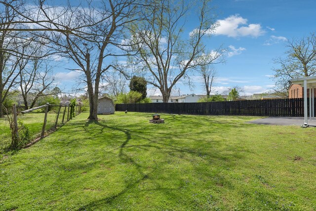 3132 Stafford Dr, Nashville, TN 37214 - view of yard with an outbuilding, a fenced backyard, a fire pit, and a storage unit
