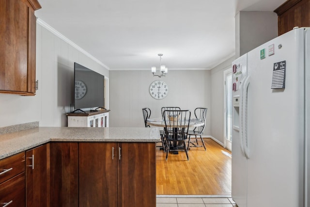 3132 Stafford Dr, Nashville, TN 37214 - kitchen with a notable chandelier, crown molding, white refrigerator with ice dispenser, and a peninsula