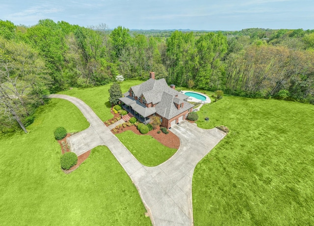 bird's eye view with a wooded view