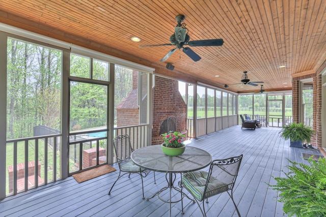sunroom / solarium featuring outdoor dining area and ceiling fan