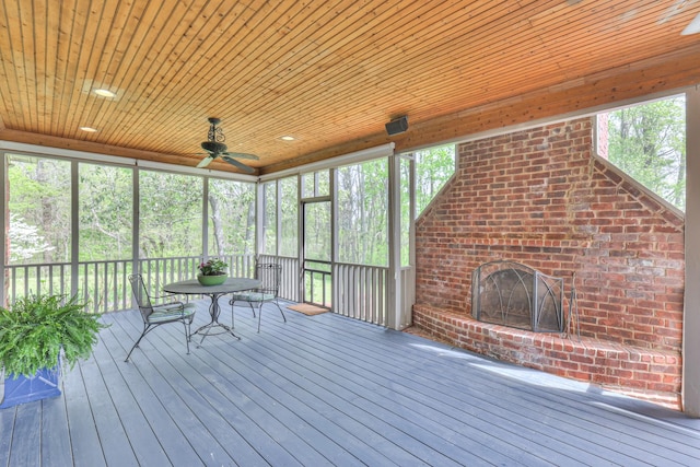 unfurnished sunroom with outdoor dining space, an outdoor brick fireplace, and ceiling fan