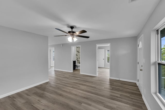 interior space with ceiling fan, wood finished floors, and baseboards