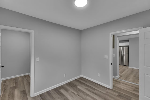 spare room featuring wood finished floors and baseboards