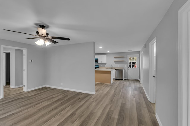 unfurnished living room featuring ceiling fan, light wood finished floors, baseboards, and recessed lighting
