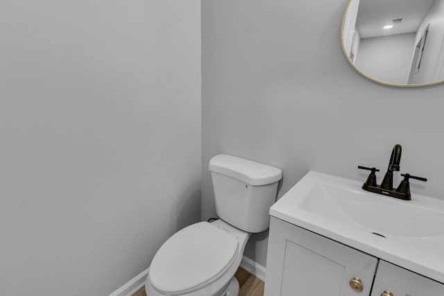 bathroom with vanity, baseboards, and toilet