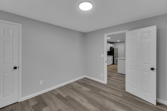 empty room featuring baseboards and wood finished floors