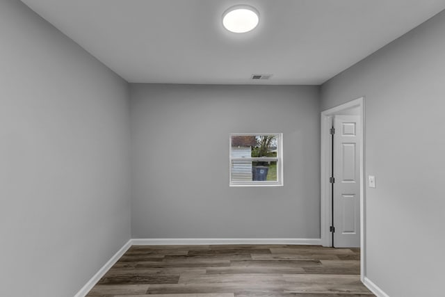 empty room with visible vents, baseboards, and wood finished floors