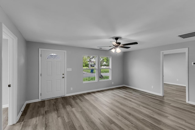 foyer entrance featuring visible vents, baseboards, a ceiling fan, and wood finished floors