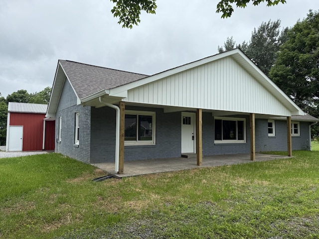 135 Locust Dr, Erin, TN 37061 - view of front of house with a front yard, a shingled roof, a patio, and brick siding