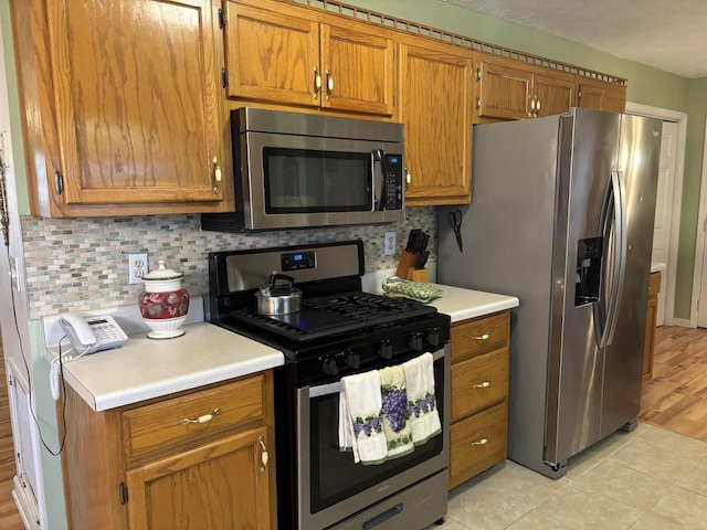 1701 Jamie Dr, Columbia, TN 38401 - kitchen featuring brown cabinets, light countertops, tasteful backsplash, and stainless steel appliances