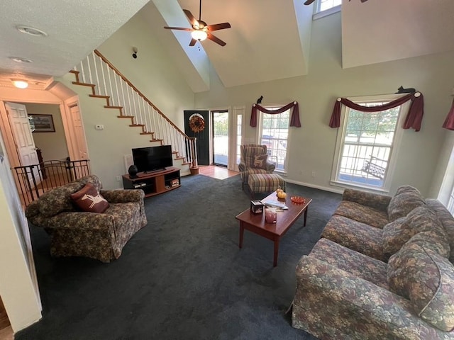 living room with a ceiling fan, carpet floors, high vaulted ceiling, and stairway