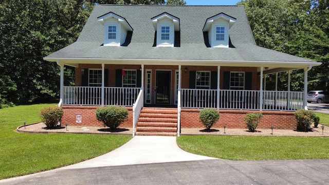 view of front of house with a shingled roof, a front lawn, and a porch
